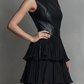 Vestido curto chique em ecopele preta e saia plissada em camadas